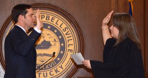 man in suit being sworn in by female judge