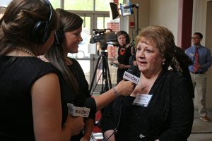 Two female reporters interviews woman