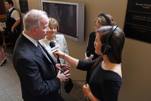 two female reports interviewing a man and woman