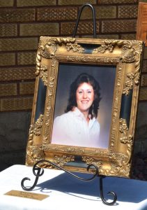smiling woman inside golden picture frame on table