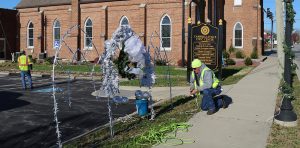 two men setting up yard ornament