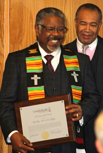 man holding award and smiling