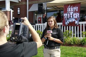 female student reporting in front of camera