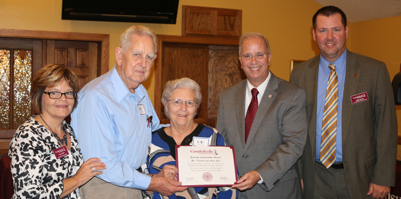 five people with man and wife holding a certificate