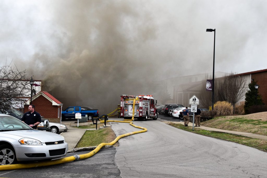 a street filled with smoke and a firetruck